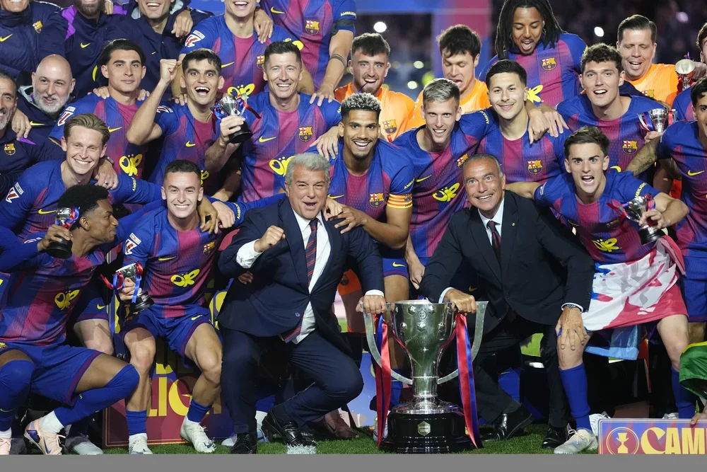 Los jugadores del Barcelona celebran el título de Liga con los directivos Joan Laporta y Rafa Yuste